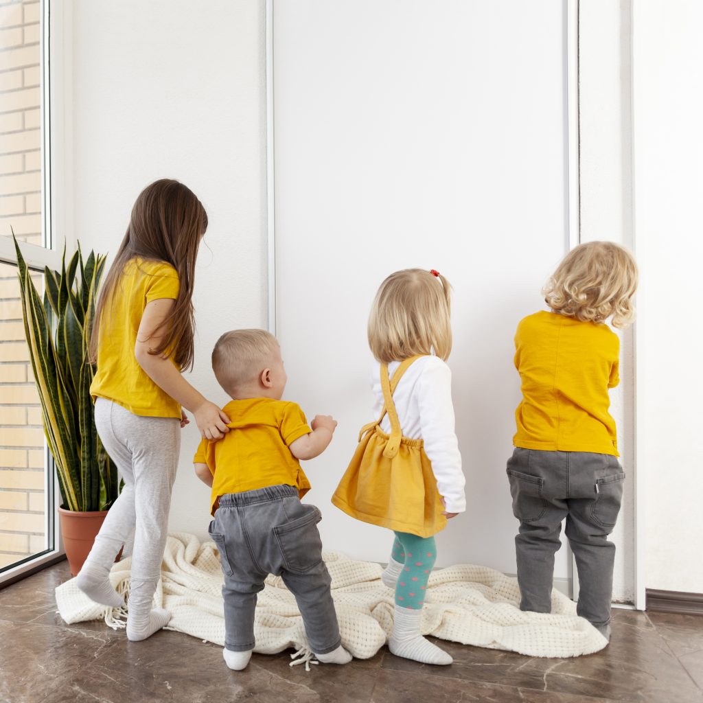 Vier Kinder in unterschiedlichen Wichteltür Altersstufen versuchen eine Tür aufzumachen